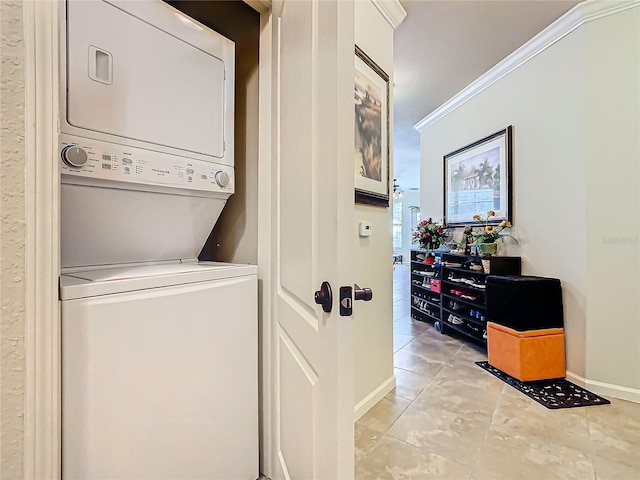 laundry room with light tile patterned floors, stacked washer / dryer, and ornamental molding