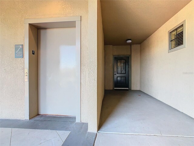 904 Charo Pkwy Unit 525, Davenport, FL 33897 - doorway to property with elevator and stucco siding