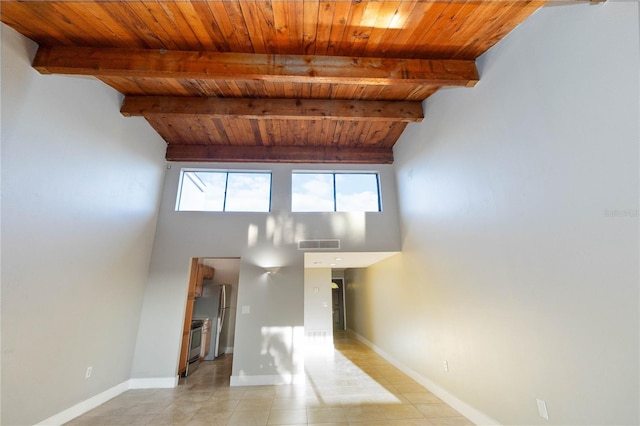 unfurnished living room with vaulted ceiling with beams, light tile patterned floors, and wood ceiling