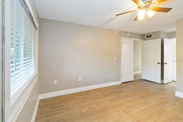 unfurnished bedroom featuring ceiling fan, a textured ceiling, and light hardwood / wood-style flooring