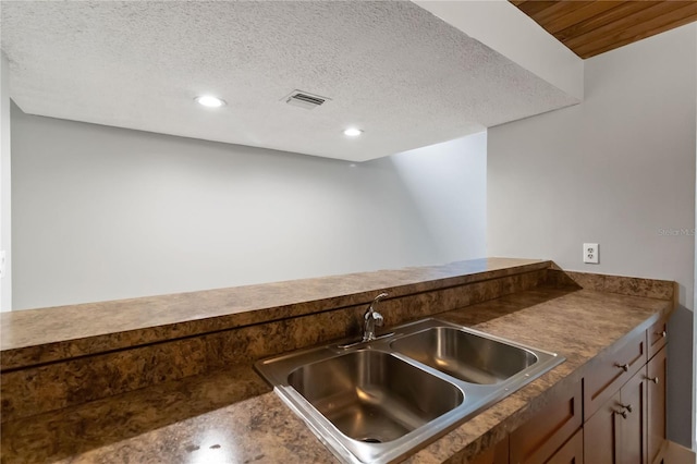 kitchen featuring a textured ceiling and sink