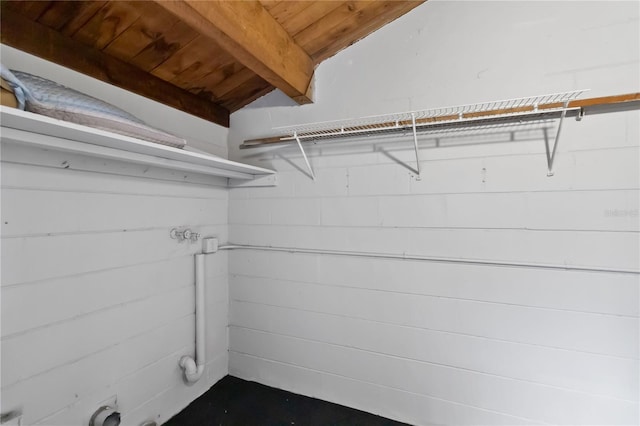 walk in closet featuring lofted ceiling with beams