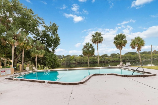 view of swimming pool with a water view and a patio