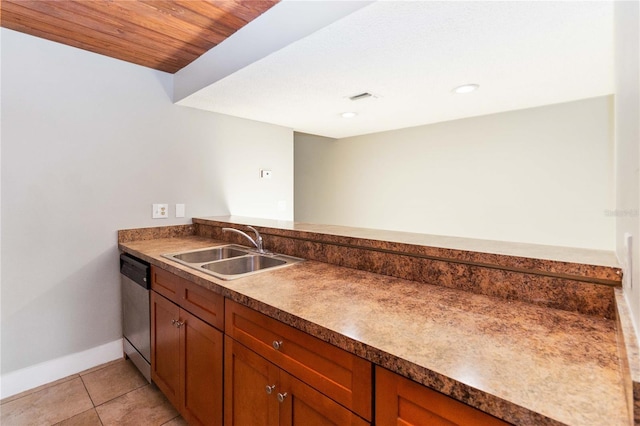 kitchen featuring brown cabinets, a sink, visible vents, and light tile patterned floors