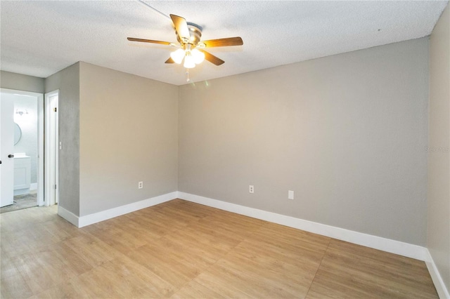 unfurnished room with a textured ceiling, a ceiling fan, and baseboards