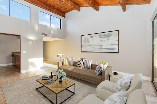 living area featuring light tile patterned floors, baseboards, visible vents, beam ceiling, and wooden ceiling