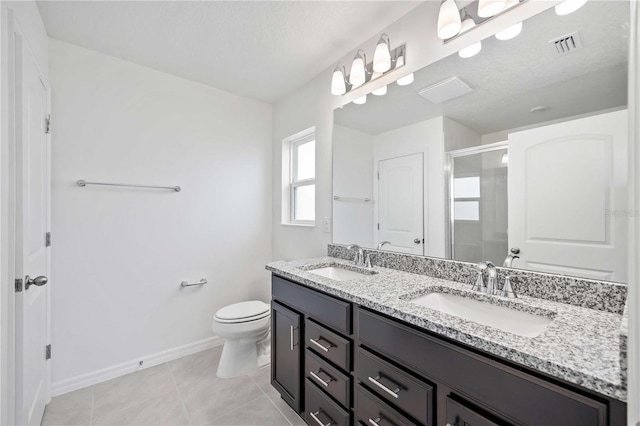 bathroom featuring a shower with shower door, vanity, toilet, tile patterned floors, and a textured ceiling