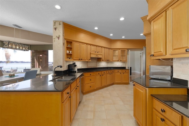 kitchen featuring dishwasher, sink, backsplash, kitchen peninsula, and a textured ceiling