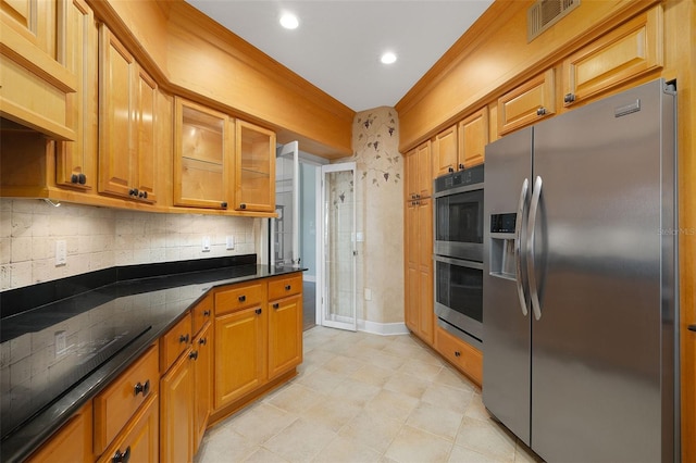 kitchen featuring tasteful backsplash, dark stone countertops, stainless steel appliances, and ornamental molding