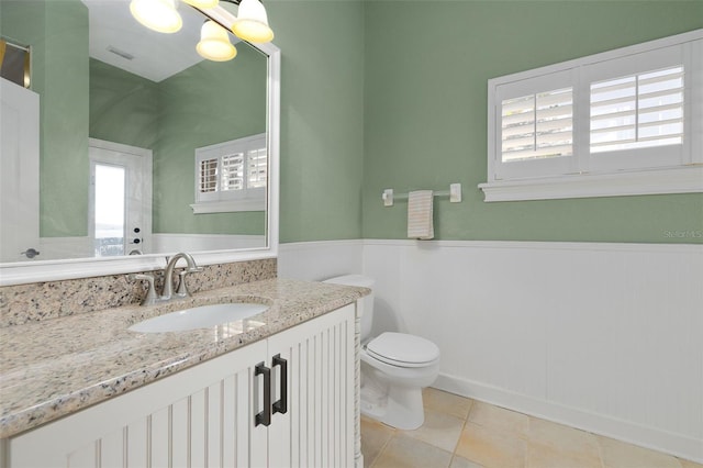 bathroom featuring tile patterned floors, vanity, and toilet