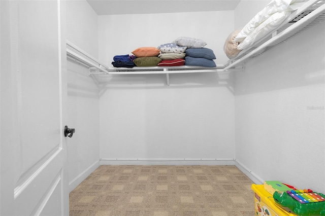 walk in closet featuring light colored carpet