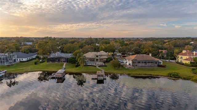 aerial view at dusk featuring a water view