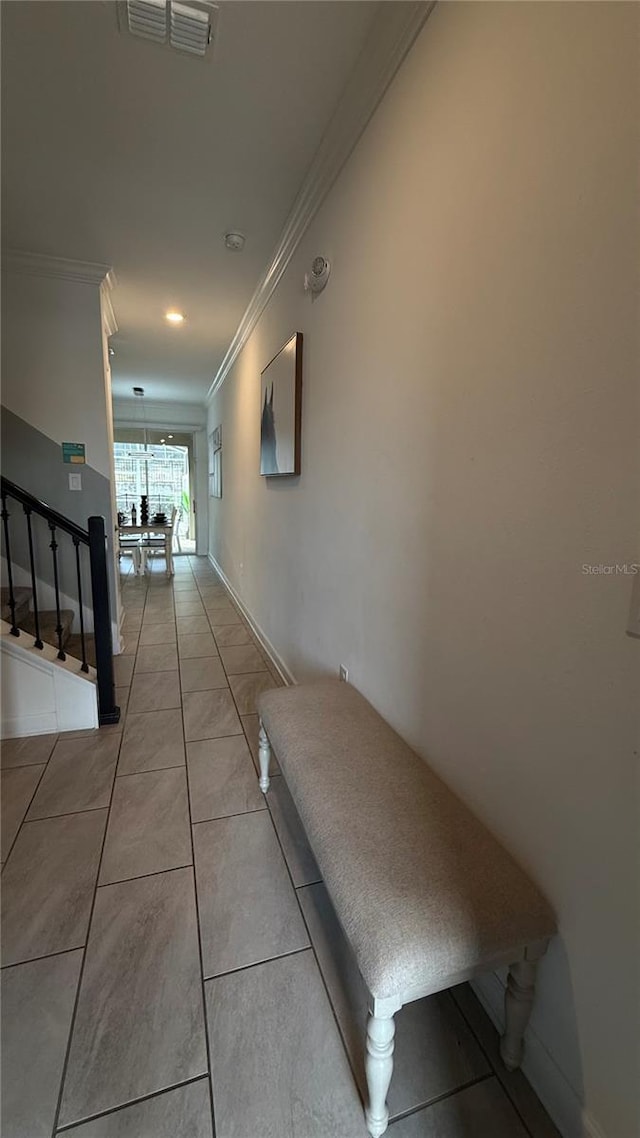 hall with light tile patterned floors and crown molding