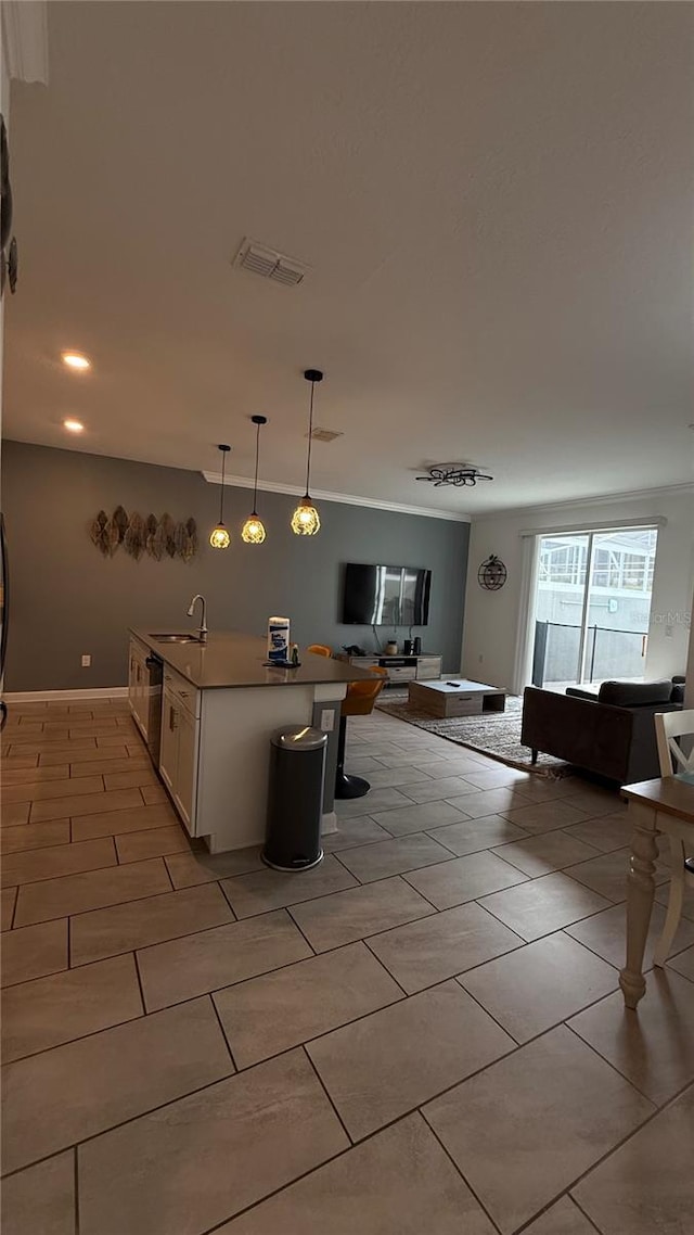 kitchen featuring hanging light fixtures, white cabinets, dishwasher, and ornamental molding