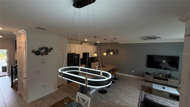 kitchen with hanging light fixtures, light tile patterned floors, white cabinetry, and ornamental molding