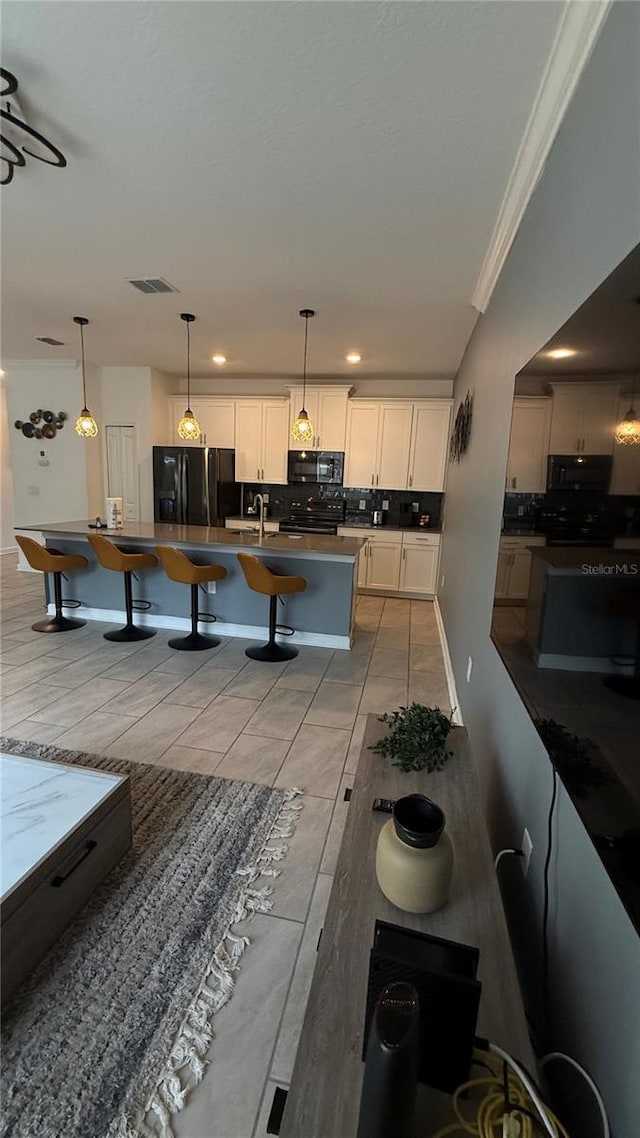 dining area with sink, light tile patterned flooring, and crown molding