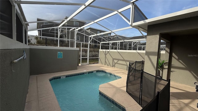 view of pool with a patio and glass enclosure