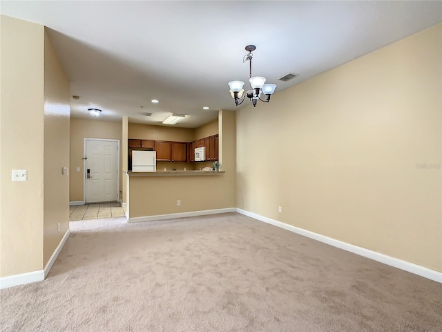 unfurnished living room featuring a chandelier and light colored carpet