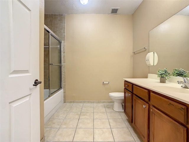 full bathroom with tile patterned flooring, vanity, toilet, and bath / shower combo with glass door