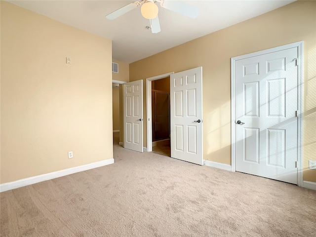 unfurnished bedroom with light colored carpet and ceiling fan