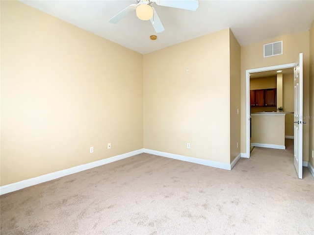 empty room with ceiling fan and light colored carpet