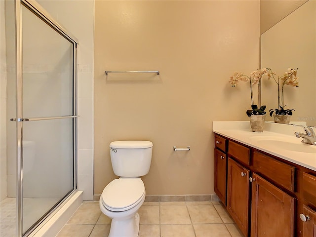 bathroom featuring toilet, vanity, tile patterned floors, and a shower with shower door