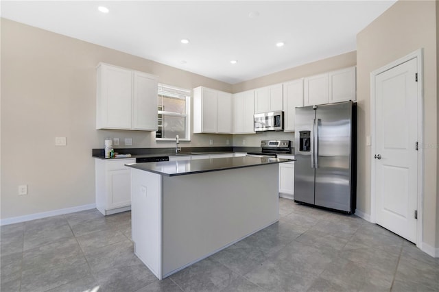 kitchen featuring appliances with stainless steel finishes, a kitchen island, sink, white cabinetry, and light tile patterned flooring