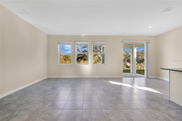 unfurnished room featuring light tile patterned flooring and a wealth of natural light