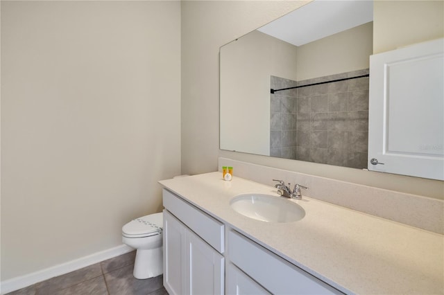 bathroom with tile patterned floors, vanity, a tile shower, and toilet