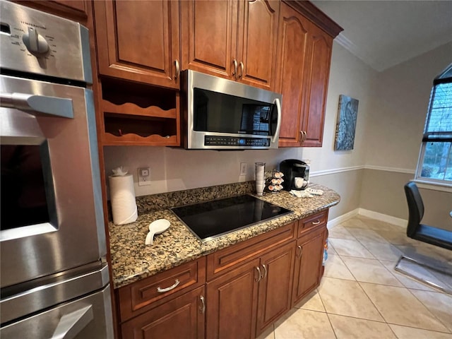 kitchen with light stone counters, light tile patterned floors, and appliances with stainless steel finishes