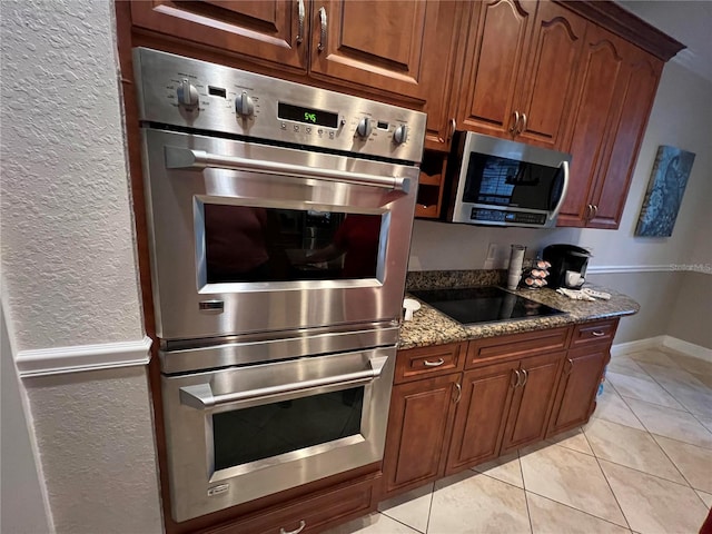 kitchen featuring light stone counters, light tile patterned floors, and appliances with stainless steel finishes