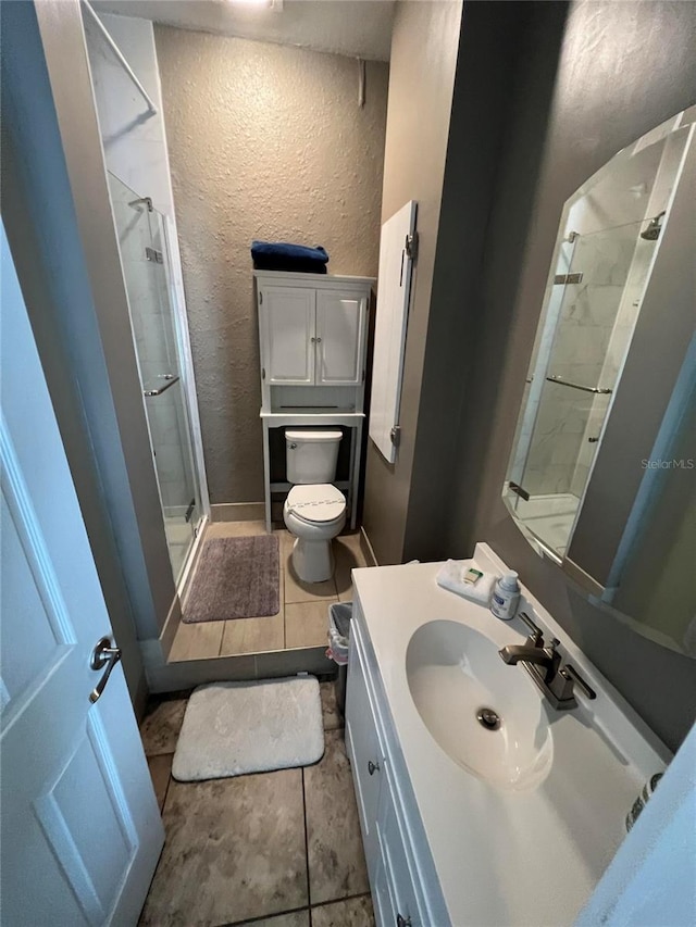 bathroom with walk in shower, tile patterned flooring, vanity, and toilet