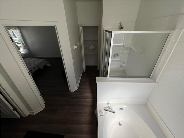 bathroom with wood-type flooring and shower with separate bathtub