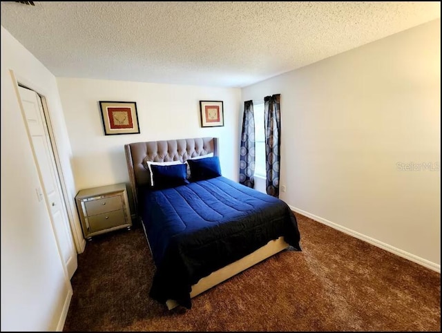 bedroom with dark carpet and a textured ceiling