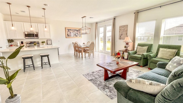 living room with plenty of natural light, light tile patterned floors, and an inviting chandelier