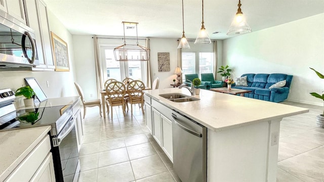 kitchen with white cabinets, appliances with stainless steel finishes, a kitchen island with sink, and sink