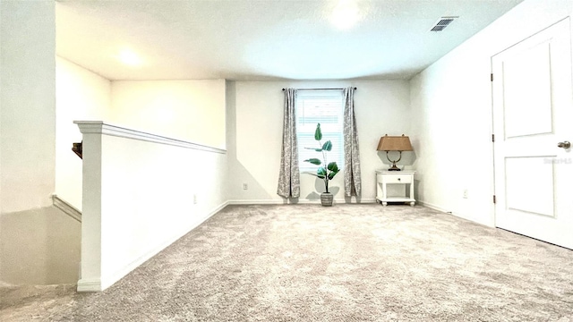 carpeted empty room with a textured ceiling