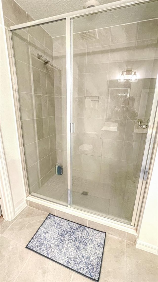 bathroom with tile patterned flooring and a shower with door