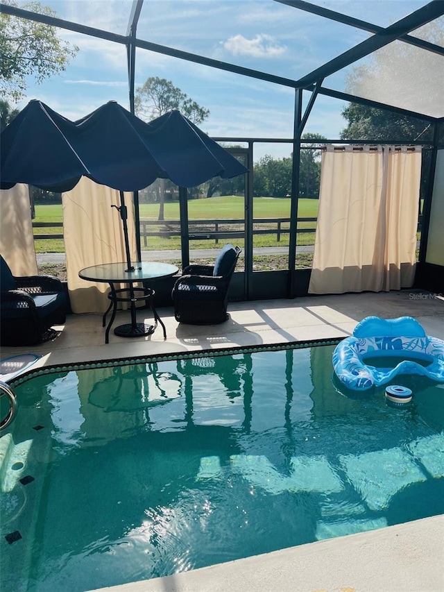 view of swimming pool featuring a lanai and a patio