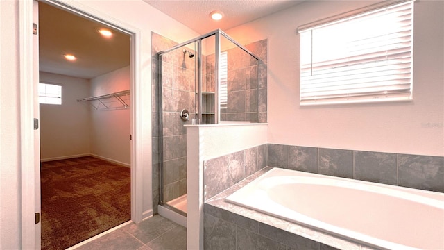 bathroom with tile patterned flooring and shower with separate bathtub