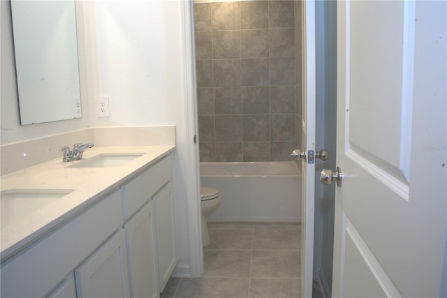 full bathroom featuring tile patterned flooring, vanity, tiled shower / bath combo, and toilet