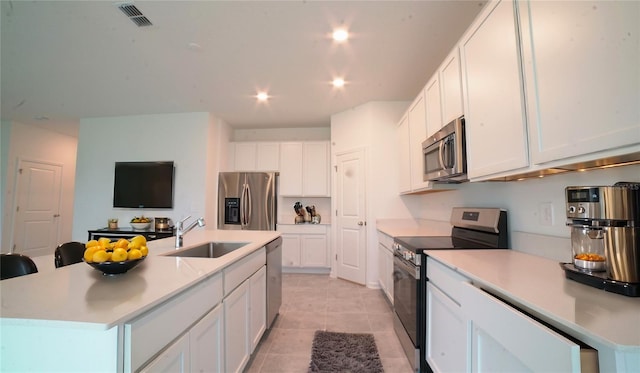 kitchen featuring white cabinets, an island with sink, and appliances with stainless steel finishes