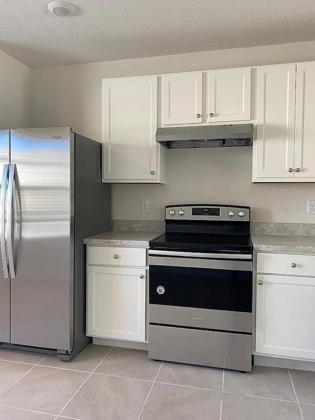 kitchen with white cabinets, light tile patterned flooring, a textured ceiling, and appliances with stainless steel finishes