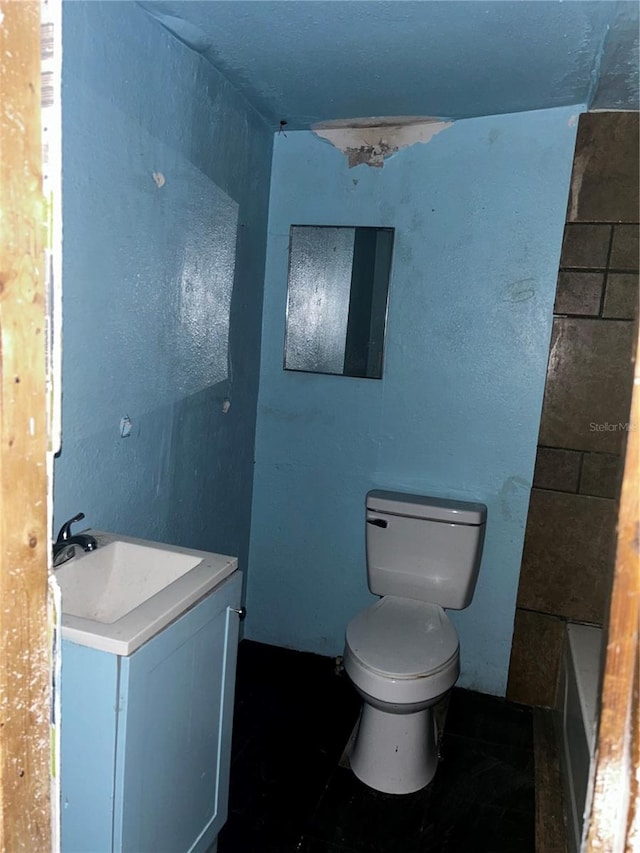 bathroom featuring vanity, a bathtub, and toilet