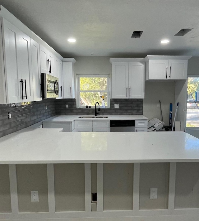 kitchen with white cabinets, appliances with stainless steel finishes, and plenty of natural light