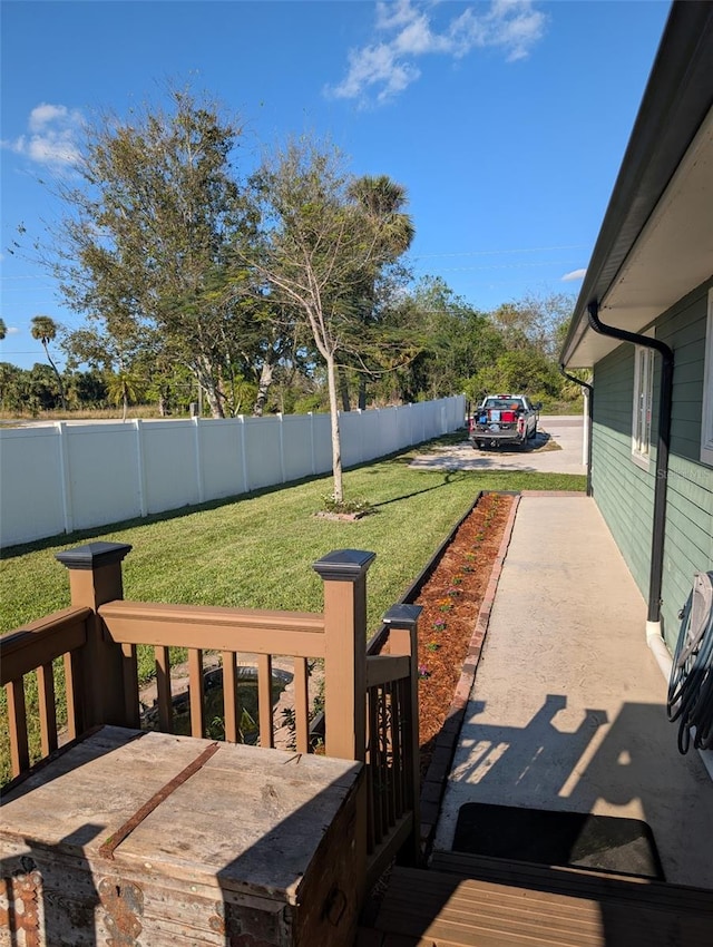 wooden terrace featuring a lawn