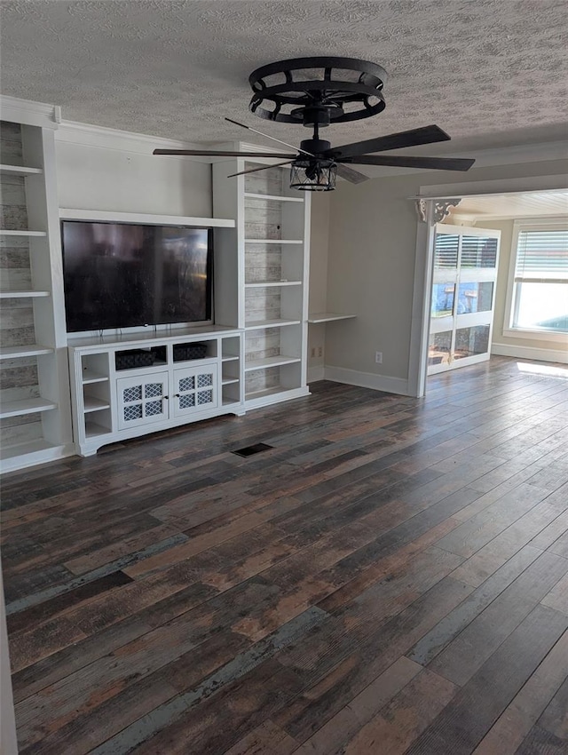 unfurnished living room featuring built in features, ceiling fan, dark wood-type flooring, and a textured ceiling