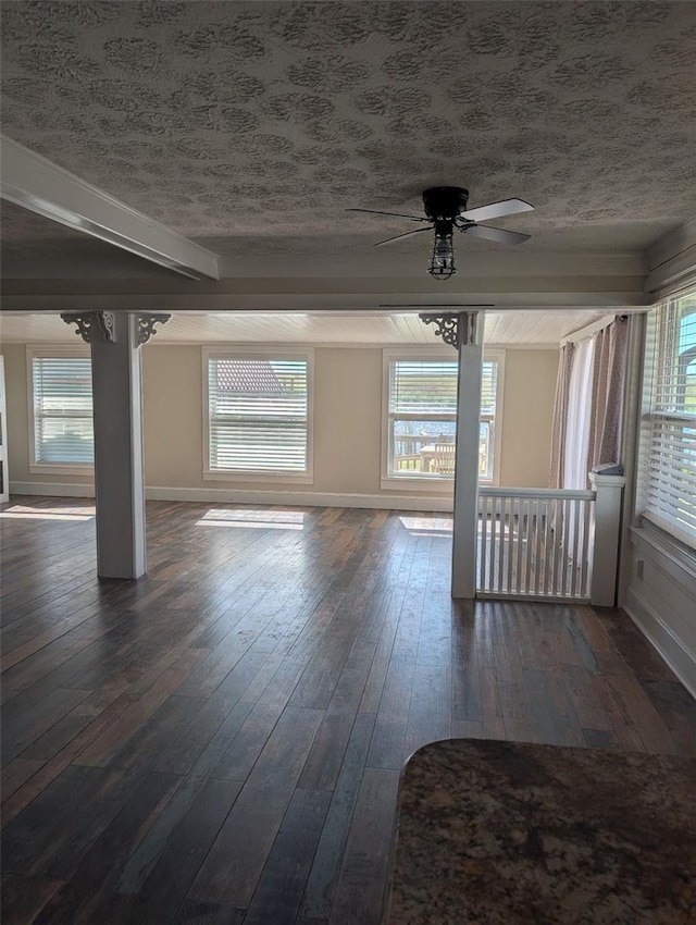 empty room featuring dark wood-type flooring, a textured ceiling, and ceiling fan