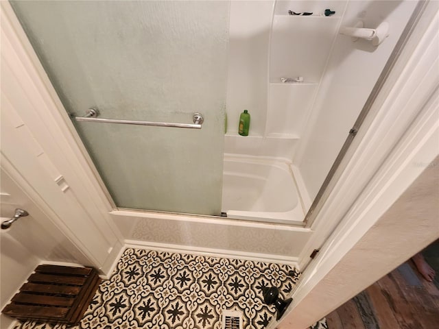 bathroom with combined bath / shower with glass door