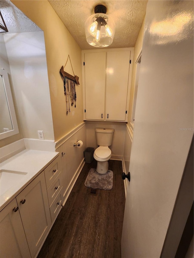 bathroom with toilet, hardwood / wood-style floors, a textured ceiling, and vanity